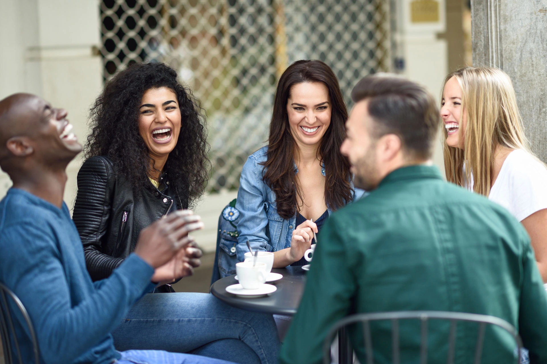 A group of diverse coed friends sharing coffee.