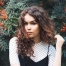 Young woman of mixed ethnicity with thick wavy hair that's been balayaged.