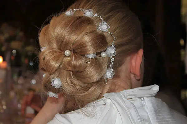 Back of woman's head showing her updo, decorated with pearls.