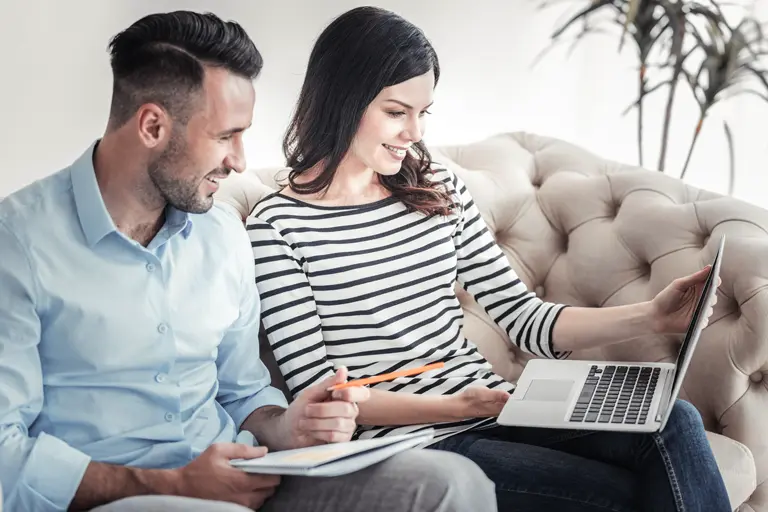 Couple are working on their values-based goals on the laptop.