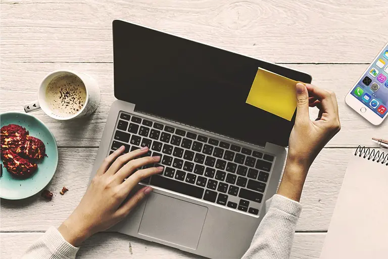 Woman on her laptop working on prioritizing her goals.